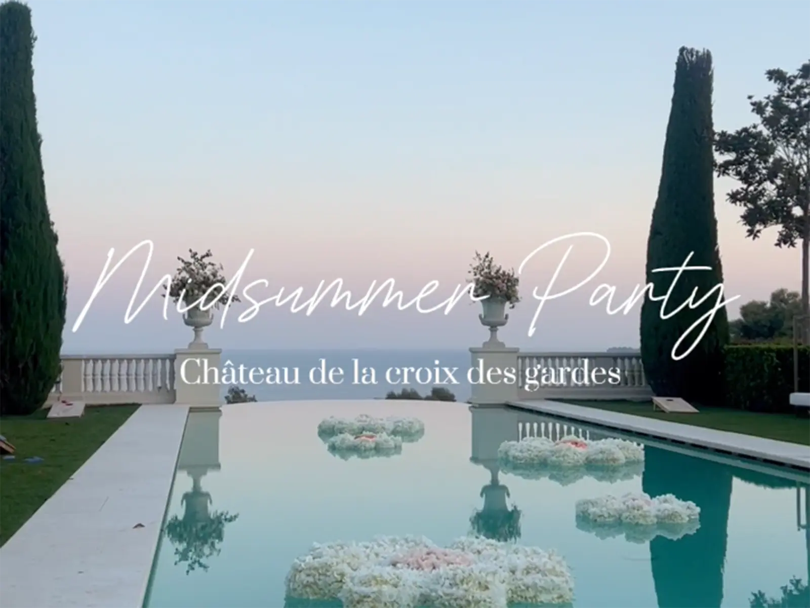 Projects 2 Elegant poolside setting at Château de la Croix des Gardes, adorned with floating flower arrangements under a pastel evening sky, invites midsummer celebration.