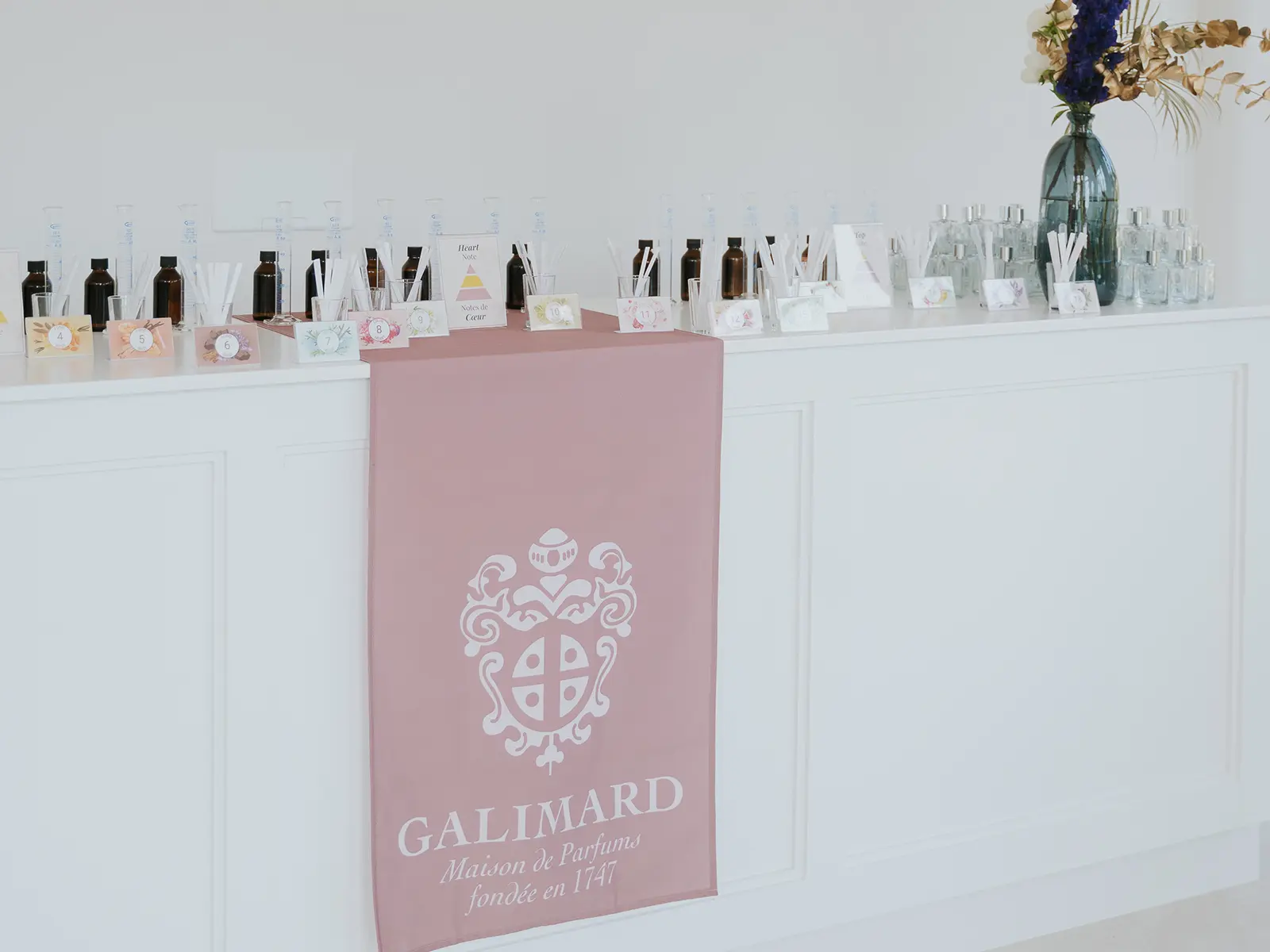 A display of perfume bottles and scent samples from Galimard, a historic perfume house established in 1747, featuring elegant decor.
